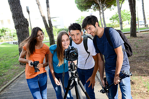 group of young photography students with teacher during outdoor photo course
