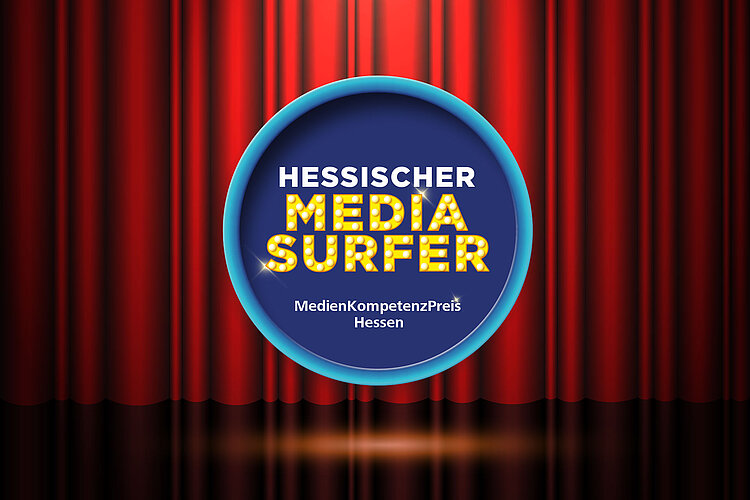Ein roter Bühnenvorhang, in dessen Mitte ein rundes blaues Schild mit der Aufschrift „Hessischer Media Surfer MedienKompetenzPreis Hessen“ in Leuchtbuchstaben steht, darunter ein reflektierender Boden.