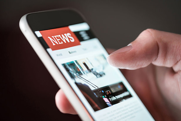 Mobile news application in smartphone. Person browsing latest articles on the internet. 