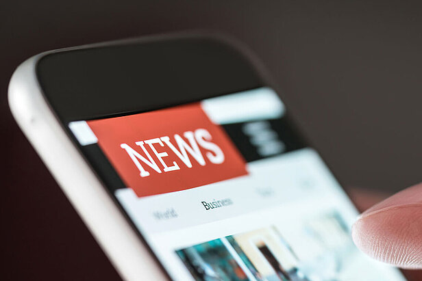 Mobile news application in smartphone. Person browsing latest articles on the internet. 