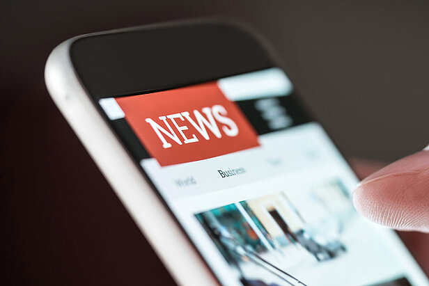 Mobile news application in smartphone. Person browsing latest articles on the internet. 