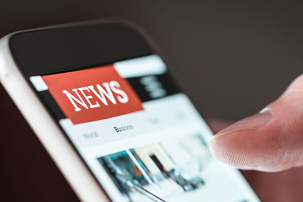 Mobile news application in smartphone. Person browsing latest articles on the internet. 