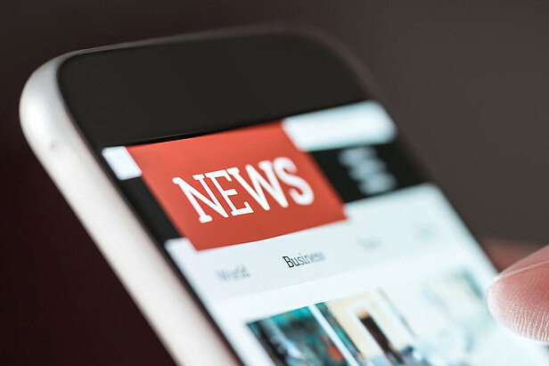 Mobile news application in smartphone. Person browsing latest articles on the internet. 