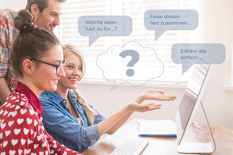 Drei junge Erwachsene sitzen an einem Schreibtisch mit einem Computer, lächeln und gestikulieren in Richtung Bildschirm. Sprechblasen enthalten Text auf Deutsch "Welche Ideern hast du für ...", "Fasse diesen Text zusammen ...", "Erkläre das einfach ...".