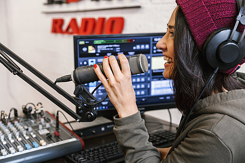 Cheerful young woman radio host broadcasting