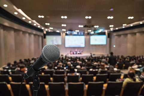 Microphone over the Abstract blurred photo of conference hall or seminar room with attendee background, Business meeting concept